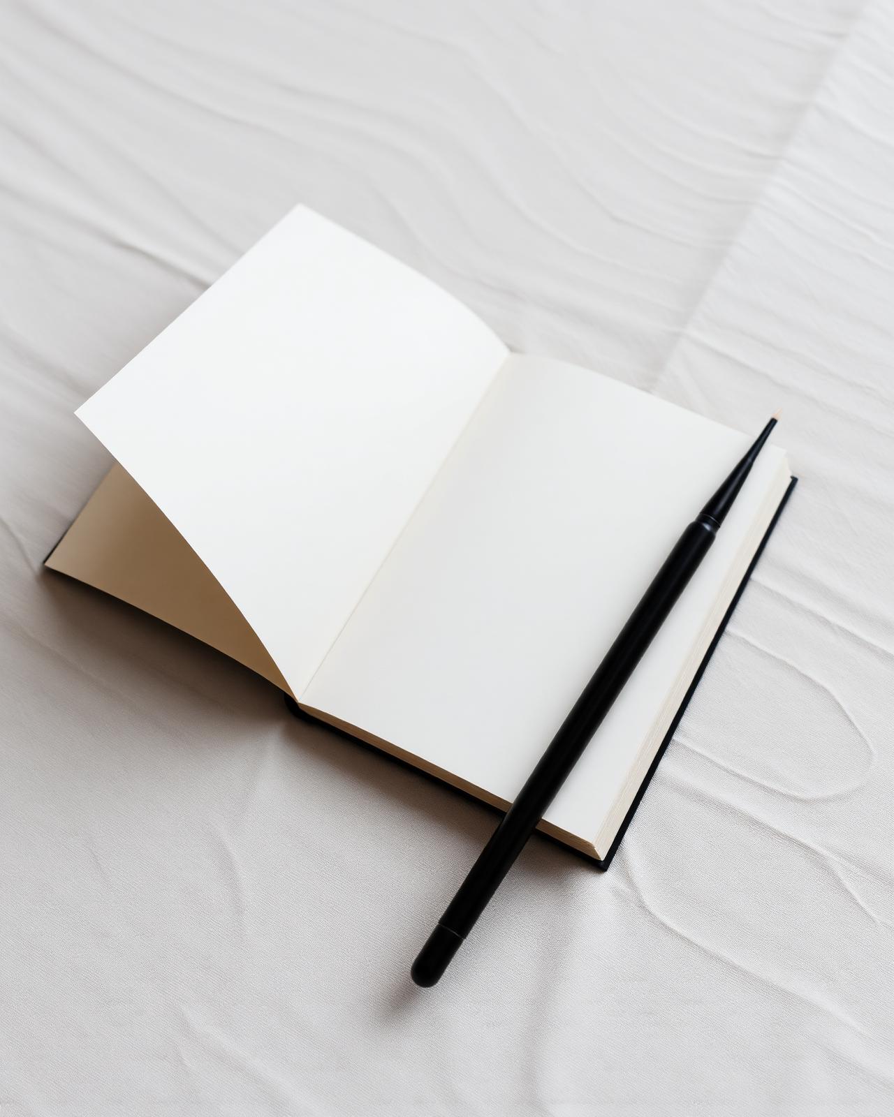 An open notebook with a black ink brush in soft daylight
